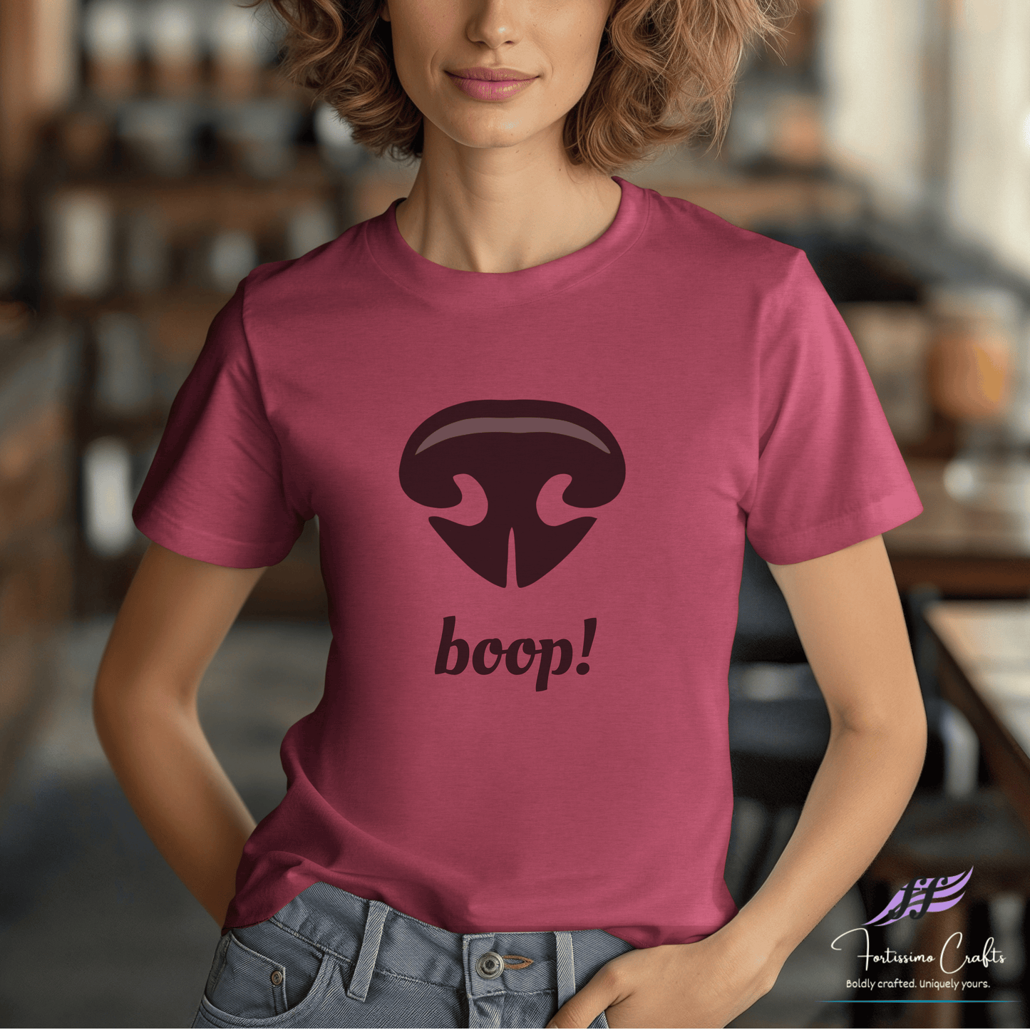 Person wearing a pink t-shirt with a black dog nose and 'boop!' text in a casual setting.