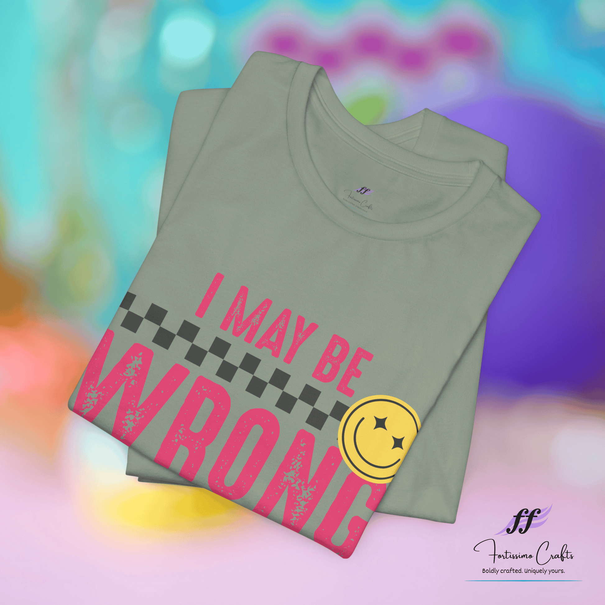 Stack of green t-shirts with pink text and yellow smiley face on a colorful background