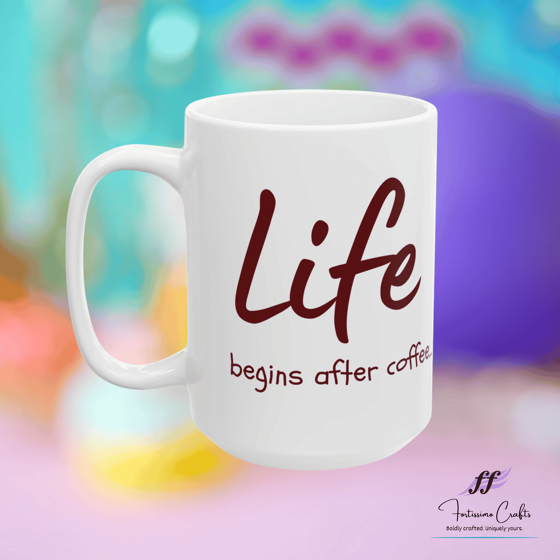 white ceramic mug with "Life begins after coffee..." in brown letters on the front on a multi-colored background