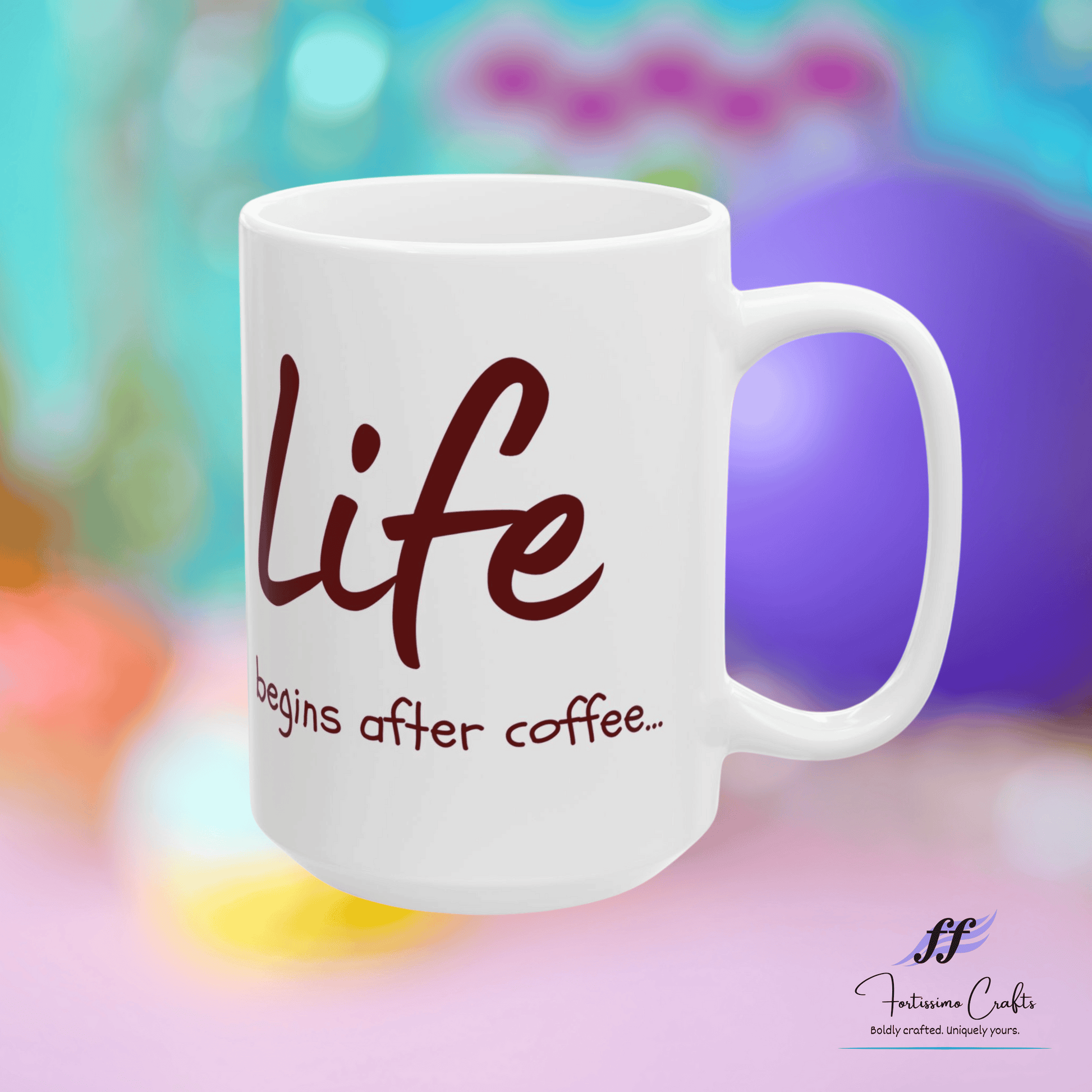 white ceramic mug with "Life begins after coffee..." in brown letters on the front on a multi-colored background