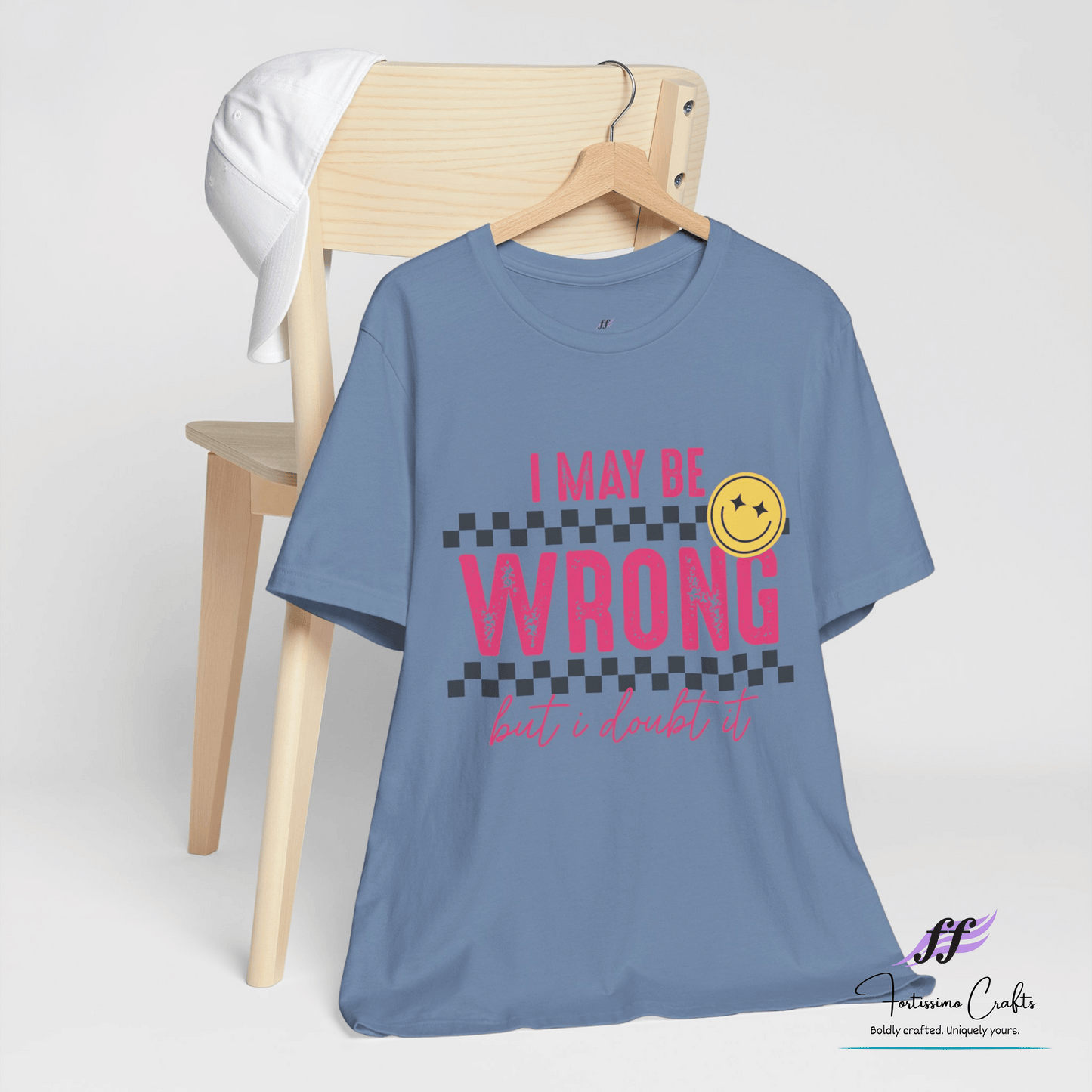 Blue t-shirt with pink text and smiley face on a white background