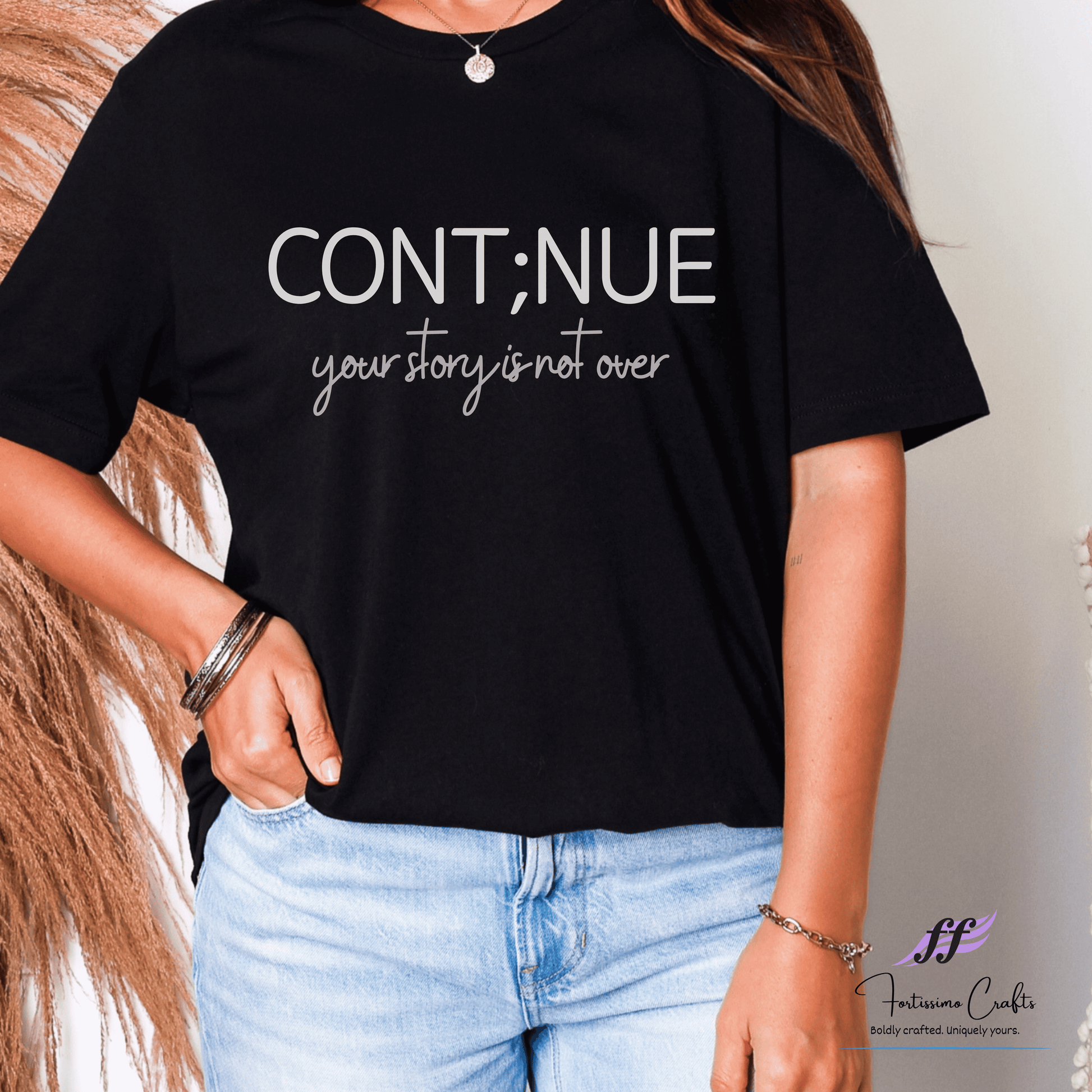 Person wearing a black t-shirt with 'CONTINUE your story is not over' text, standing against a neutral background.