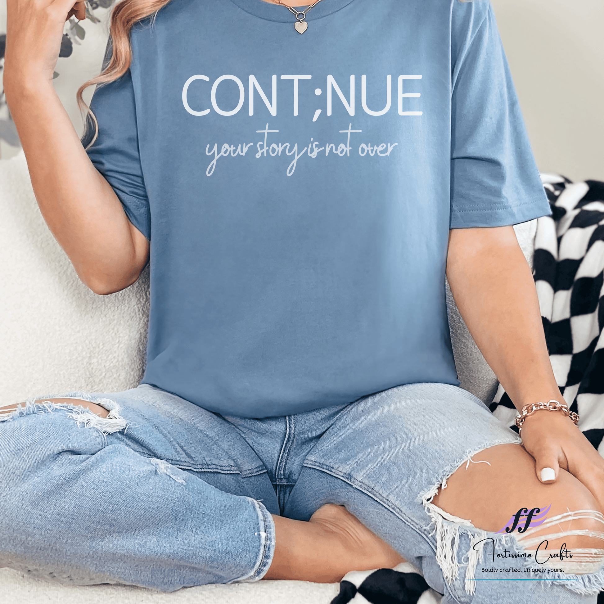 Person wearing a blue t-shirt with 'CONT;NUE your story is not over' text.