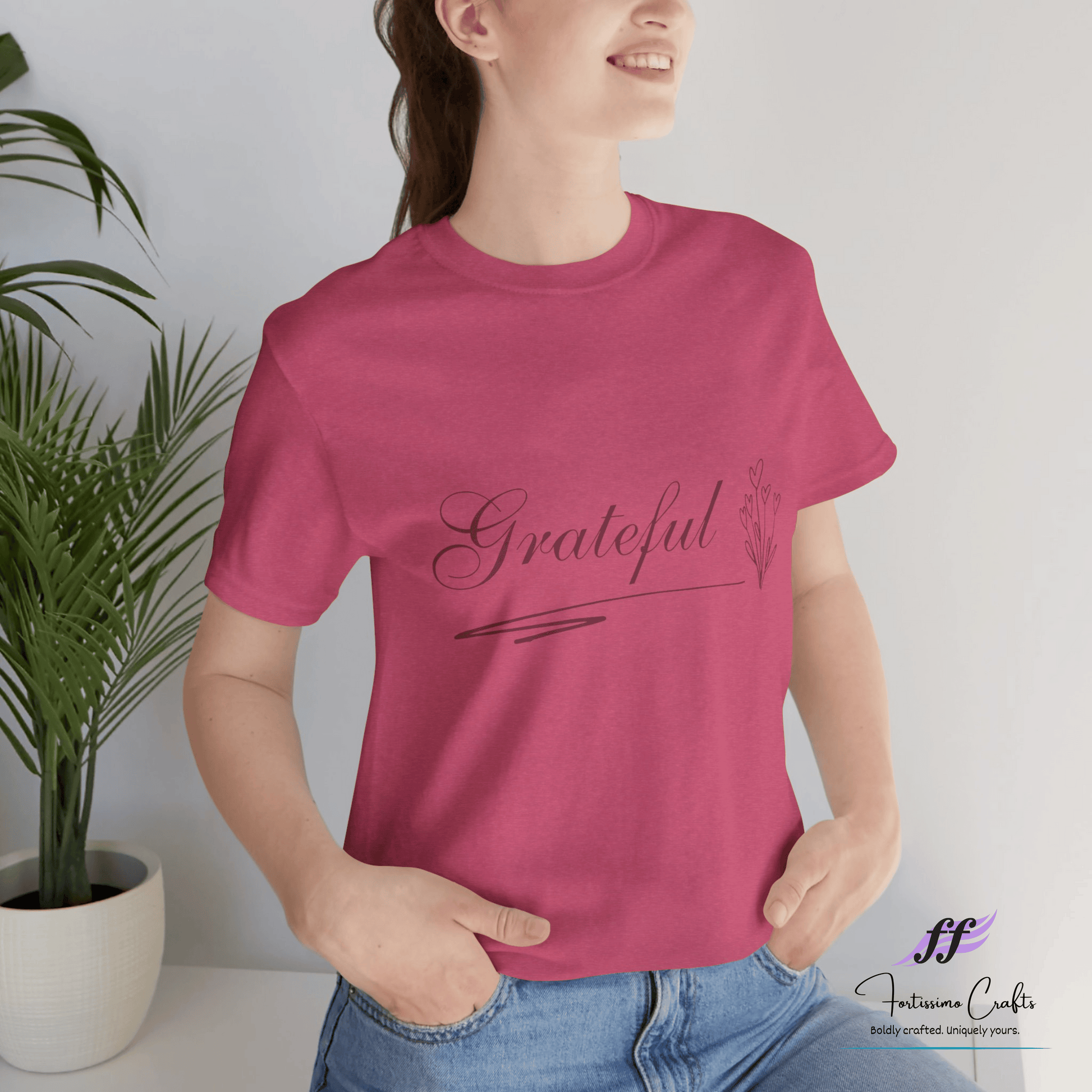 Woman wearing a raspberry colored t-shirt with 'Grateful' text on the front
