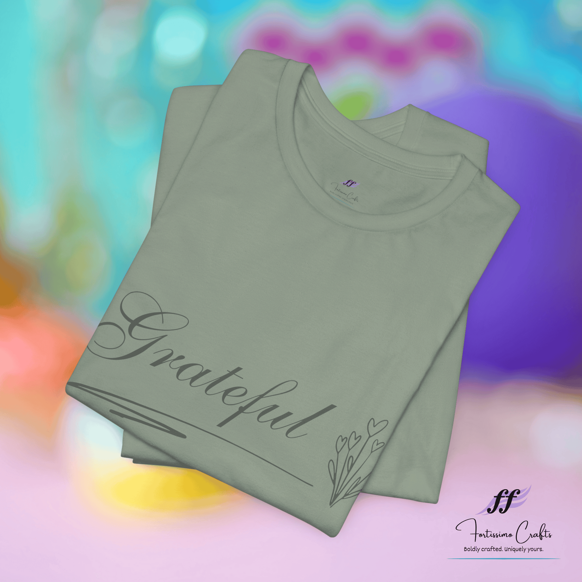 Stack of green t-shirts with 'Grateful' text on a colorful background