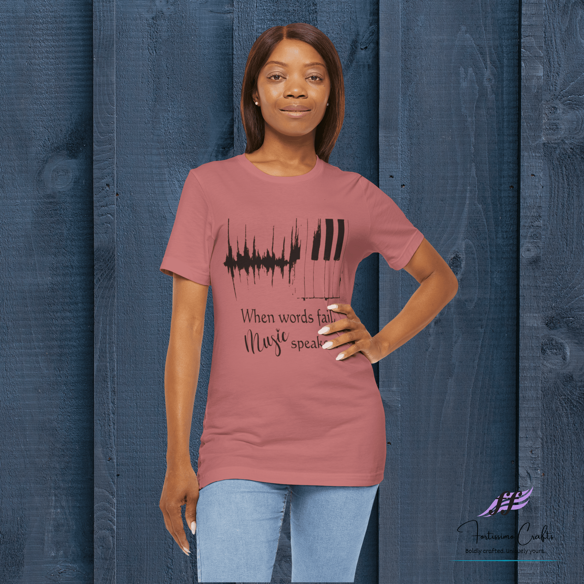 Woman wearing a pink t-shirt with a music-themed design against a blue wooden panel background