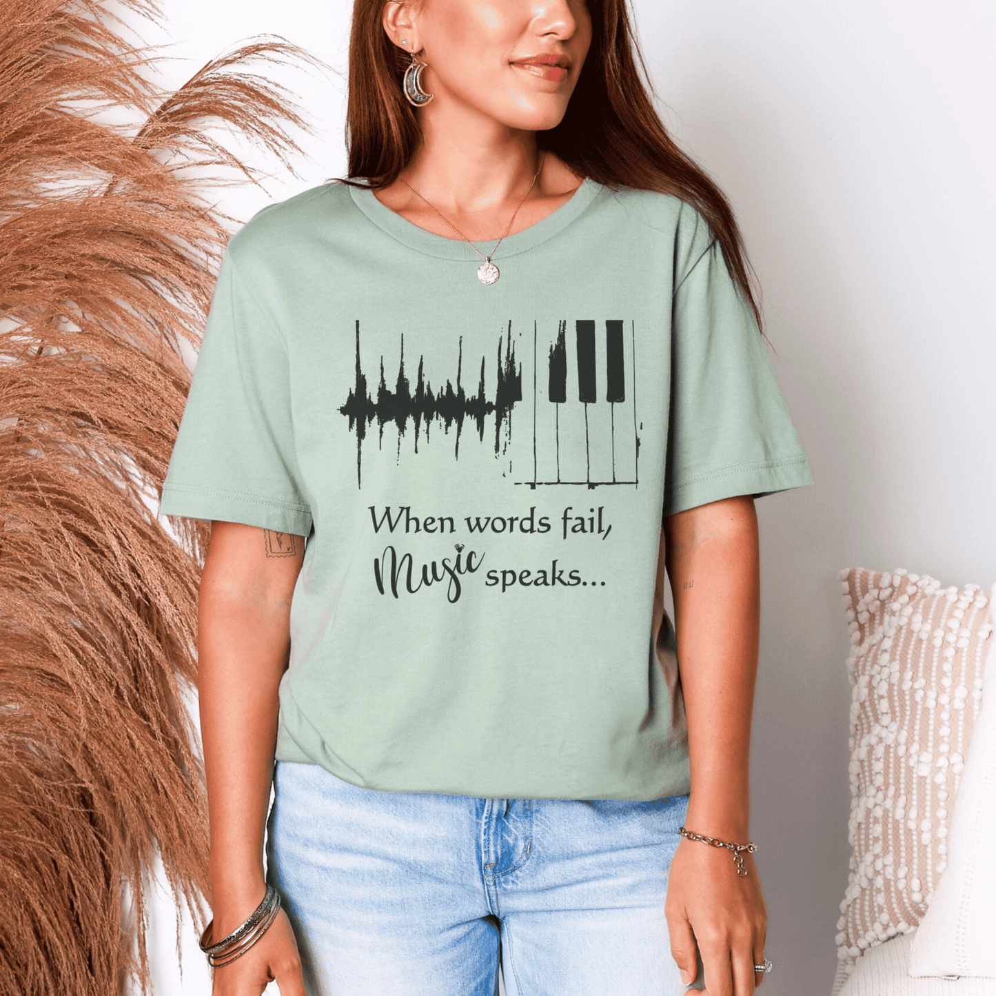 Person wearing a light green t-shirt with a music-themed design and text.