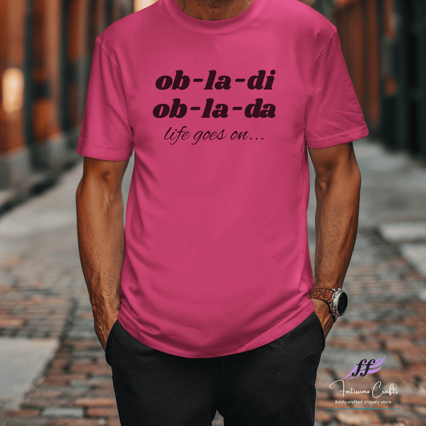 Person wearing a pink t-shirt with text on a blurred street background