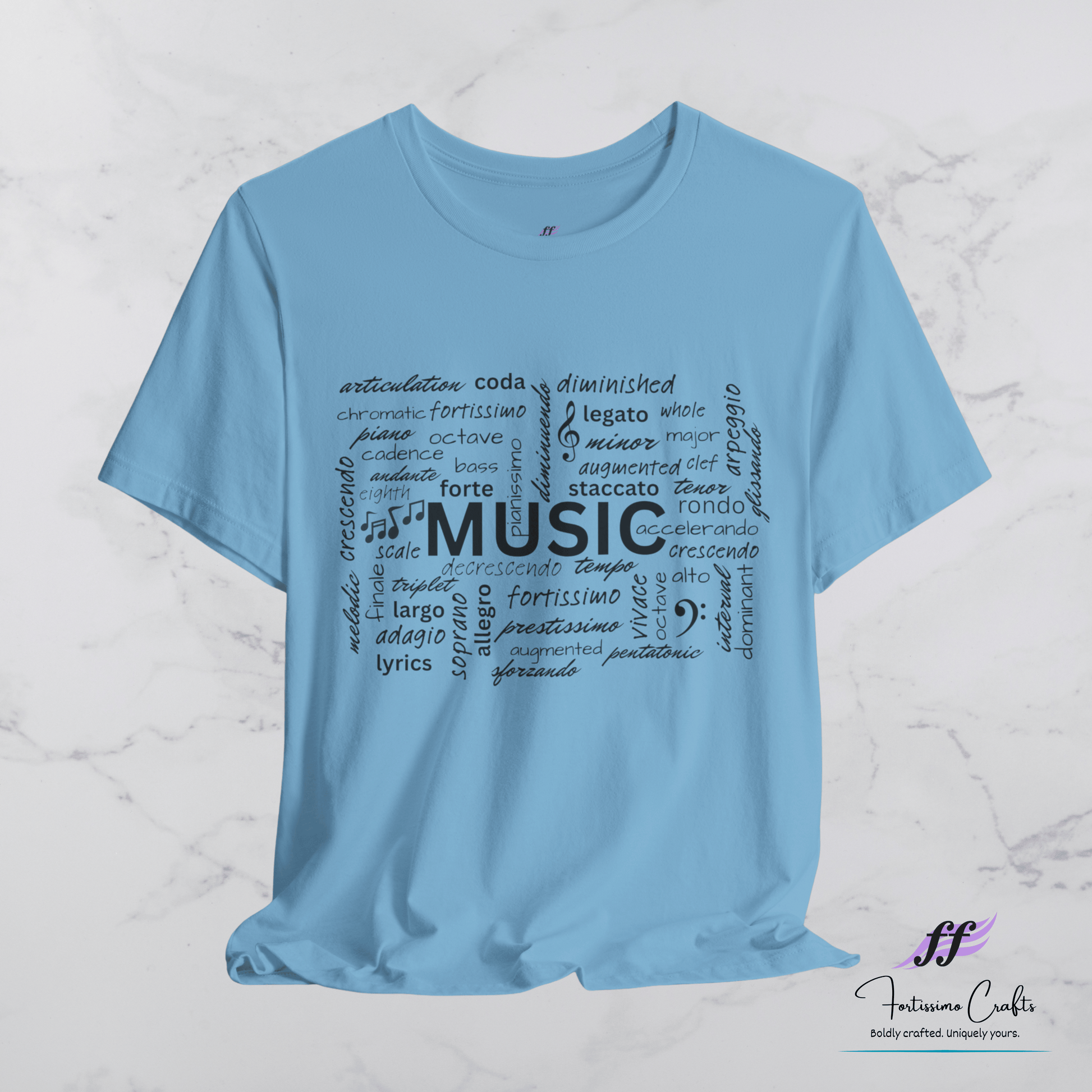 Light blue t-shirt with music-themed text design on a white marble background