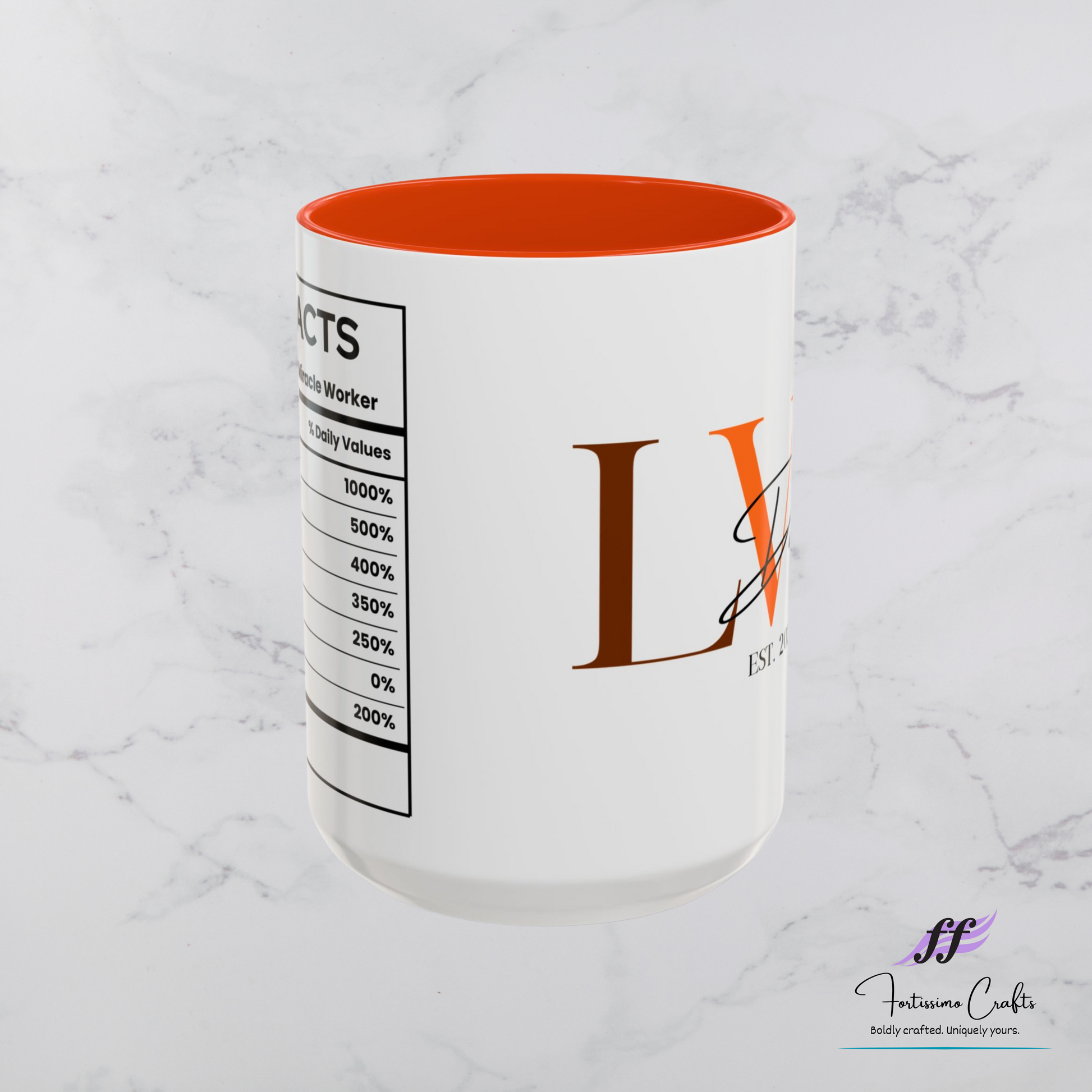 White mug with orange interior and decorative branding on a marble surface