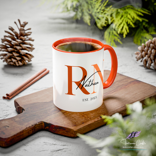 White mug with orange rim and personalized design on a wooden cutting board with coffee and decorations.