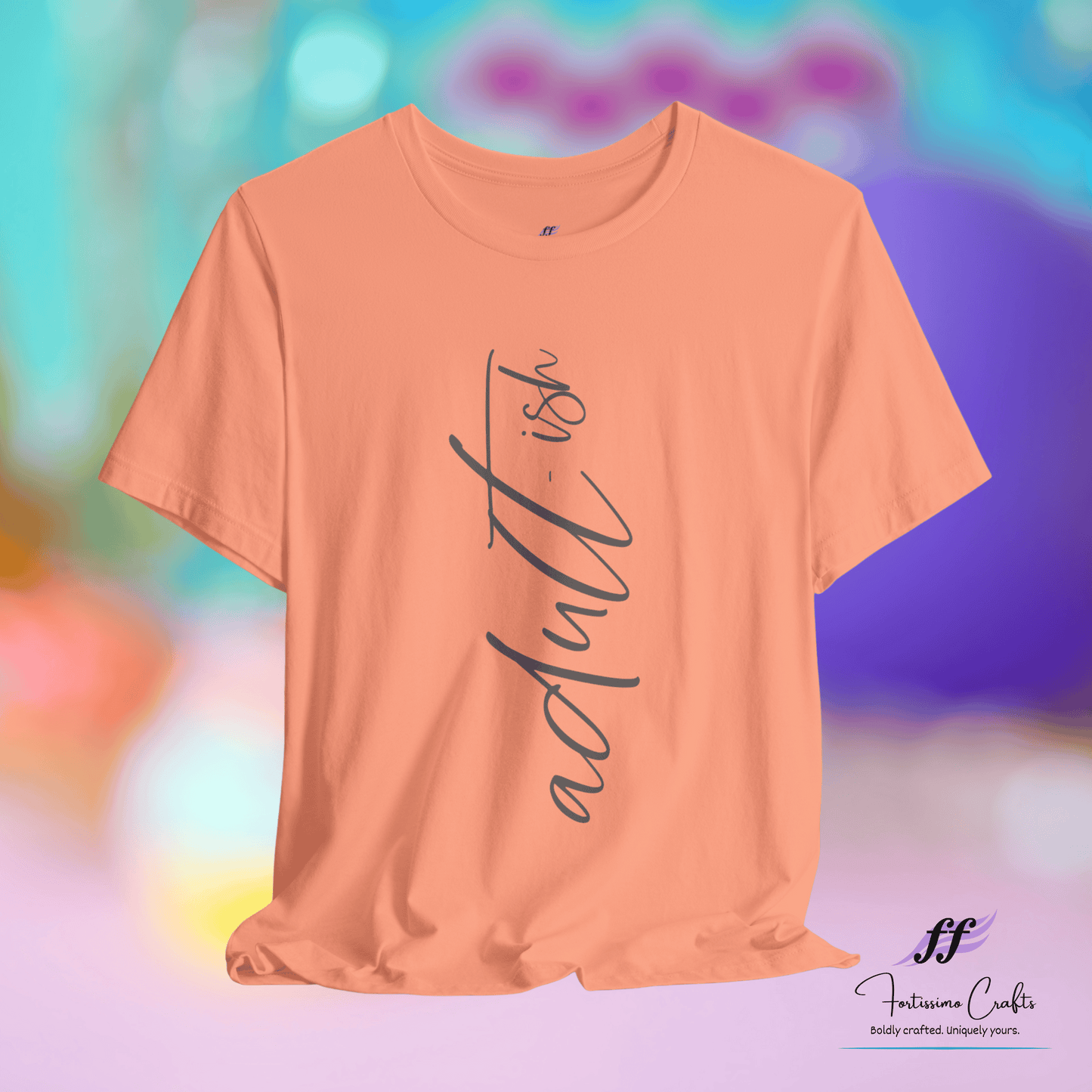 Peach t-shirt with 'adultish' text on a colorful blurred background