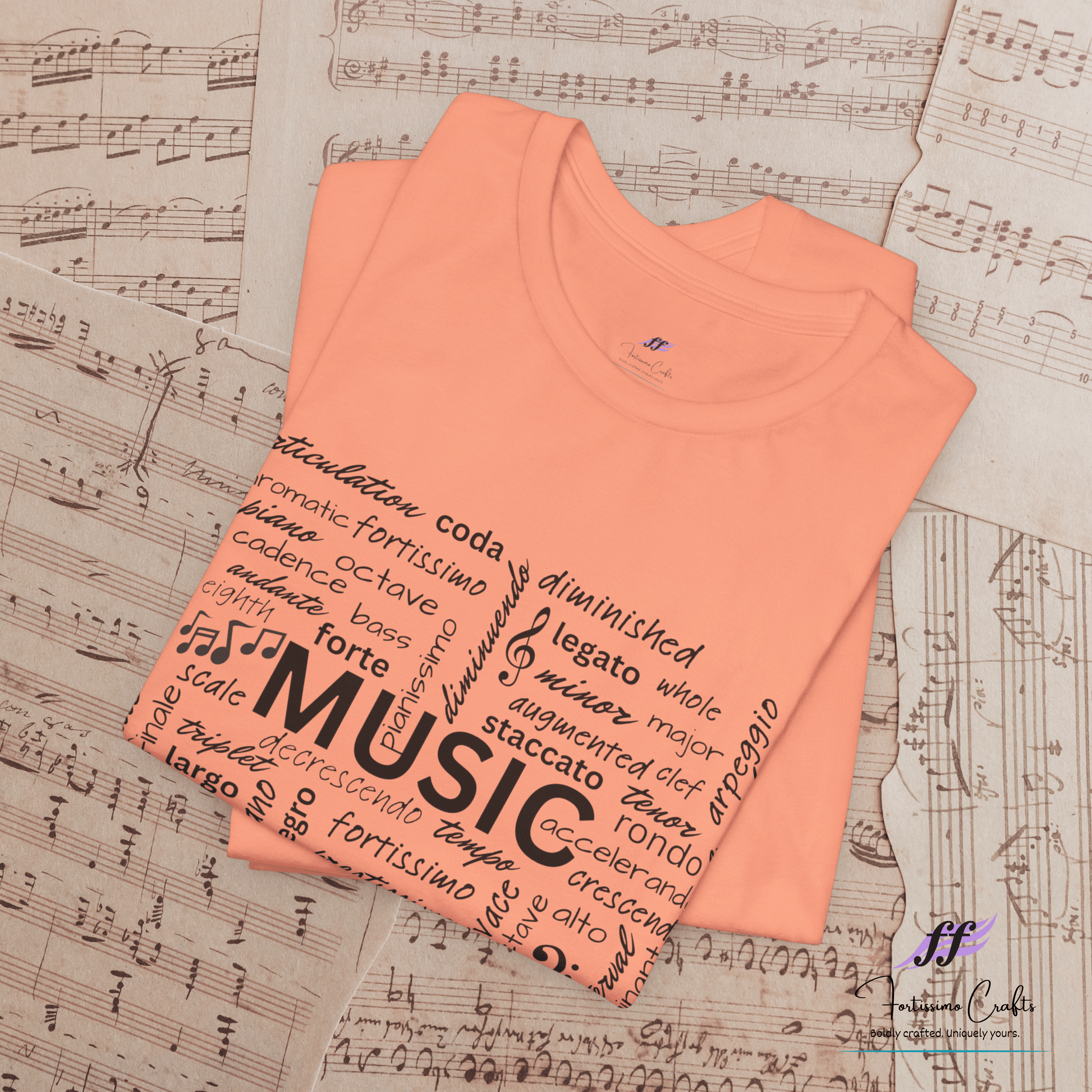 Folded peach t-shirt with music-themed text on a sheet music background