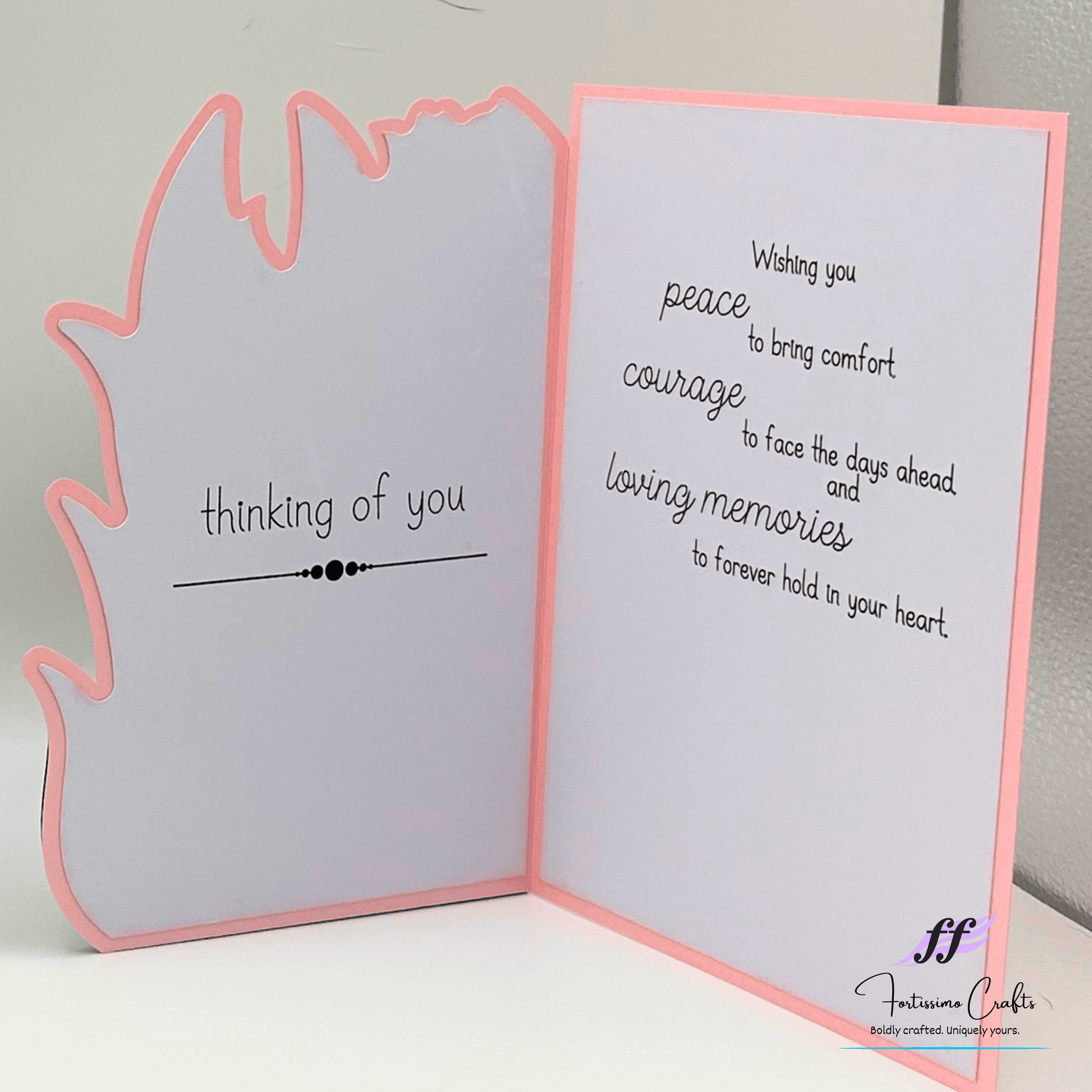 Open card with text 'thinking of you' and 'Wishing you peace, courage, and memories' on a plain background.