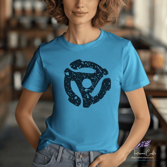 Person wearing a blue t-shirt with a black graphic design in a blurred indoor setting
