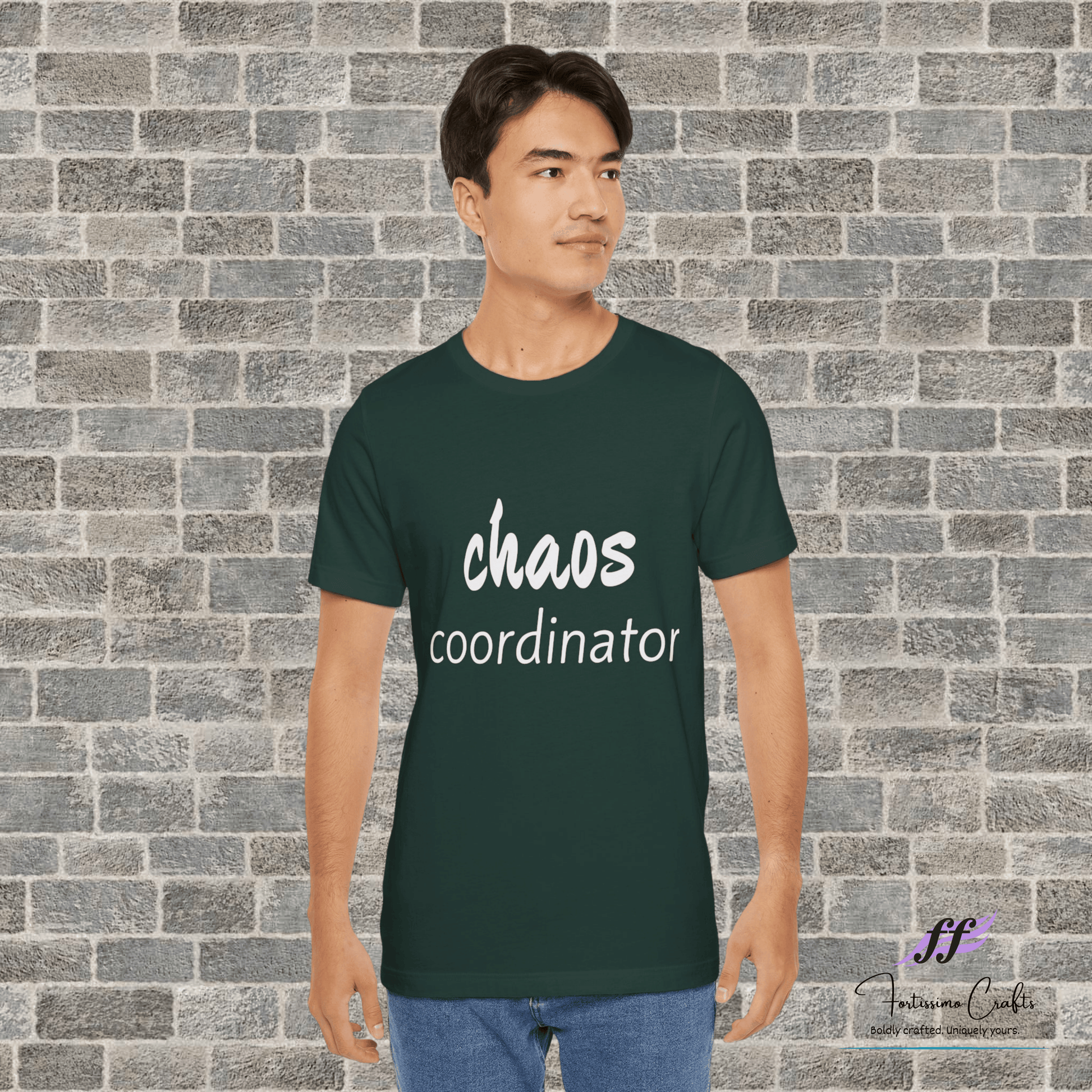 Person wearing a green t-shirt with 'chaos coordinator' text against a brick wall.