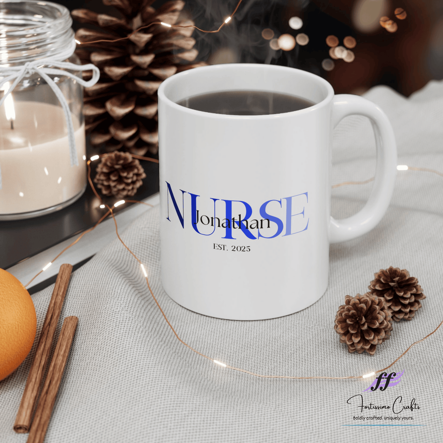 White ceramic mugs with NURSE in blue with the name Jonathan on top and est. 2025 underneath sitting on a table with pinecones